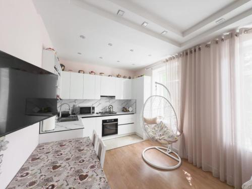 a white kitchen with a chair in a room at Central 2-Bedroom Cozy New Flat in Chişinău