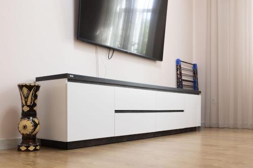 a white dresser with a tv on top of it at Central 2-Bedroom Cozy New Flat in Chişinău