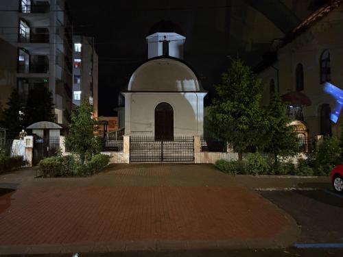 un piccolo edificio bianco con un campanile di notte di Apartament S 22 a Roman