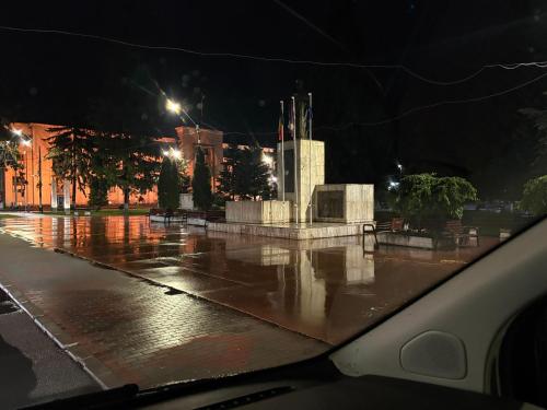 Apartament S 22 في رومان: شارع مبتل ليلاً مع نصب تذكاري تحت المطر