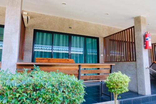 a wooden bench in front of a window at Nam Sai Loft Resort in Chao Lao Beach