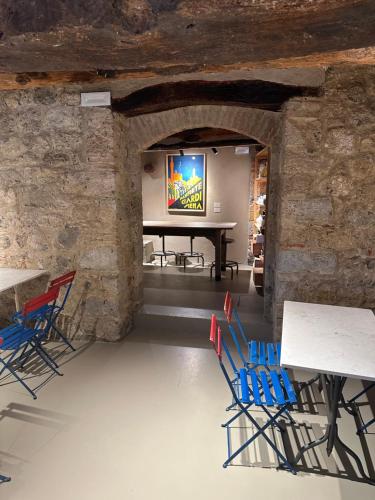 a room with chairs and a table in a stone wall at Rooms and Wine al Castello in Monteriggioni
