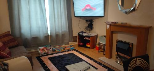 a living room with a tv and a fireplace at Comfortable holiday home in Basildon Essex in Laindon