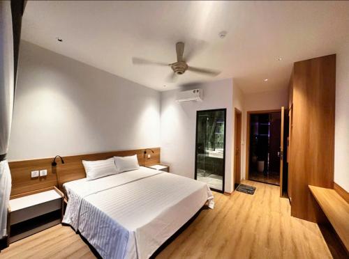 a bedroom with a white bed and a ceiling fan at Flamingo1 Ibiza Hai Tien in Nam Khê