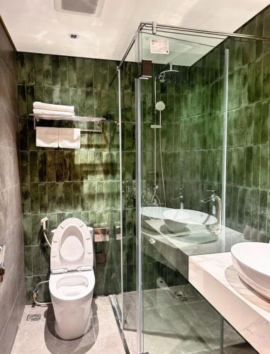 a bathroom with a toilet and a shower and a sink at Flamingo1 Ibiza Hai Tien in Nam Khê