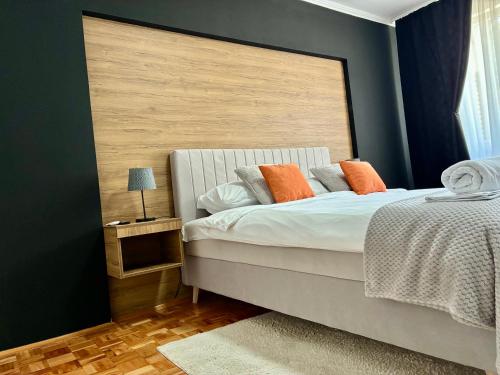 a bedroom with a large bed with orange pillows at Apartman Minja in Višegrad