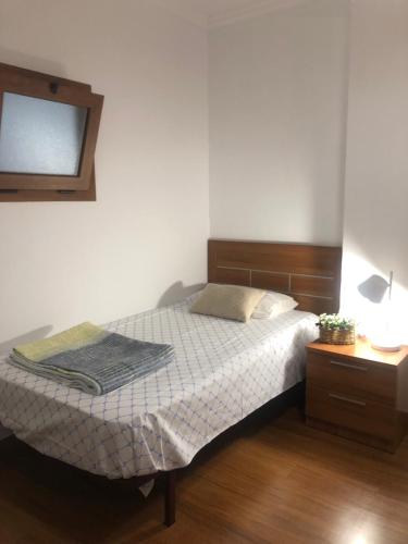 a bedroom with a bed with a mirror and a table at Gaviota 2do in Marín