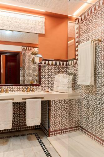 a bathroom with a sink and a mirror at Alhambra Palace Hotel in Granada