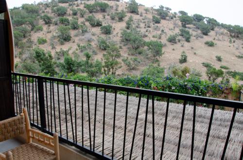 a balcony with a view of a hill at harmony surf lodge in Taghazout