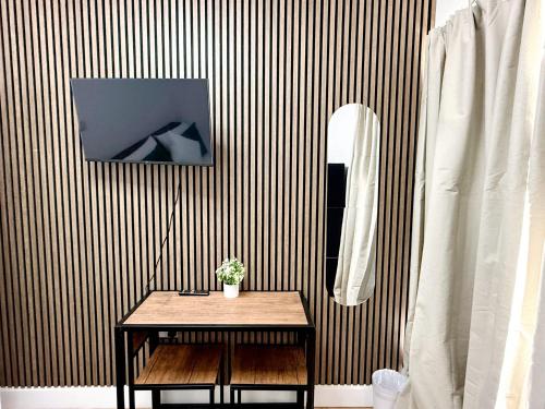 a table in front of a wall with a mirror at BB-Spacious 1 Double room in Wembley in London