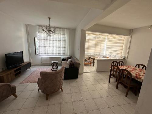 a living room with a table and a dining room at Hera Pansiyon in Gökçeada