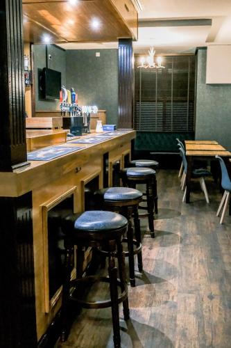 a bar in a restaurant with stools at a counter at The Hillside Hotel & Restaurant in Hillside