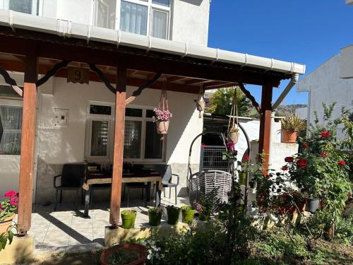 a patio with a wooden pergola with a table at Hera Pansiyon in Gökçeada