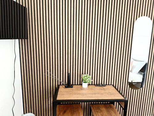 a wooden table with a potted plant on it in a room at BD-Stylish Double bed in Wembley in London