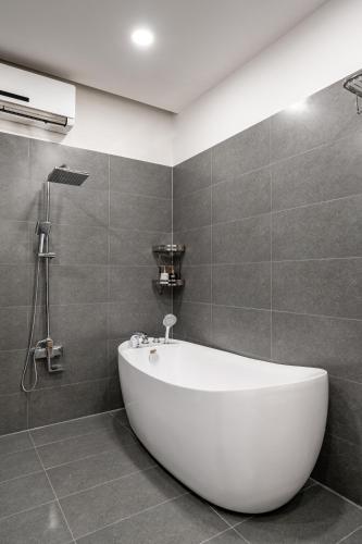 a white tub in a bathroom with a shower at A Boi Apartment at District 3 in Ho Chi Minh City
