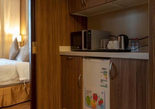 a kitchen with a microwave on top of a refrigerator at Golden Tower Hotel Al Khobar Corniche in Al Khobar
