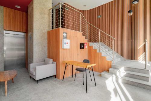 a lobby with a staircase and a table and chairs at Limehome Lisbon Defensores de Chaves in Lisbon