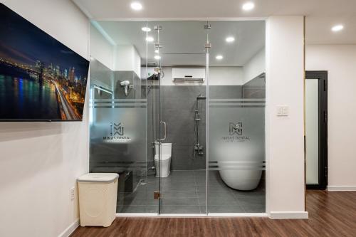 a bathroom with a glass shower with a toilet at A Boi Apartment at District 3 in Ho Chi Minh City