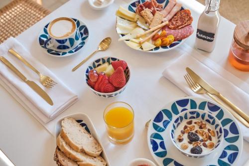 ein Tisch mit Tellern voller Frühstücksspeisen und Getränken in der Unterkunft Hotel Gaio 7 in Santiago de Compostela