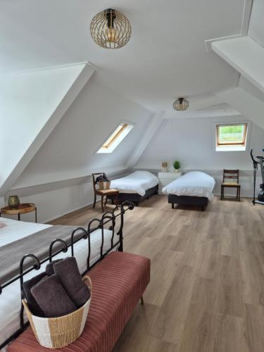 a attic bedroom with two beds and a red couch at luxe villa met privé zwembad en jacuzzi in Zeewolde