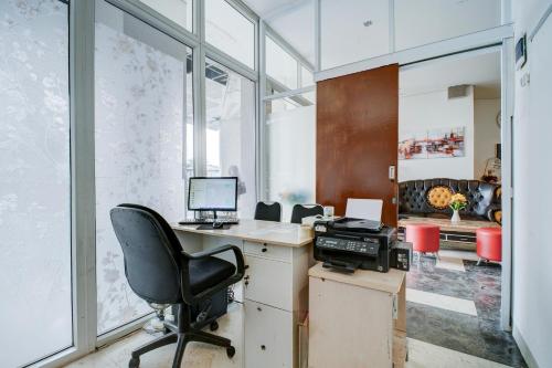 an office with a desk with a computer and a chair at Collection O near Terminal Pulo Gebang formerly Sentra Timur - Tower Sapphire in Jakarta