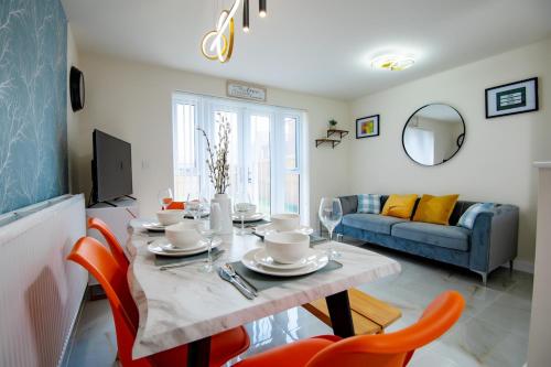 a dining room with a table and chairs and a couch at Luxury 5BDR with City Access, Free Parking and Wi-Fi in Ince-in-Makerfield