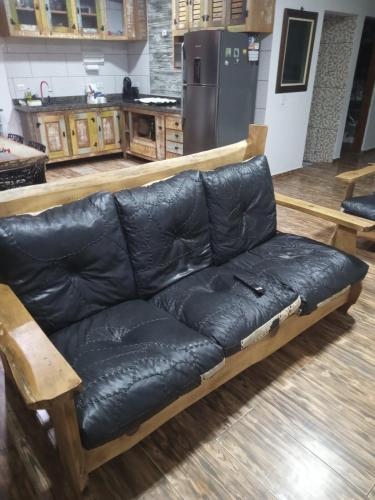Un sofá negro en medio de una cocina. en Casa das Palmeiras 2, en Itanhaém