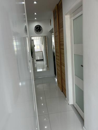 a hallway with a mirror and a white tile floor at BM Apartament in Augustów