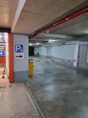 an empty parking garage with a parking sign on a wall at Albania Haven Apartment 20B in Tirana