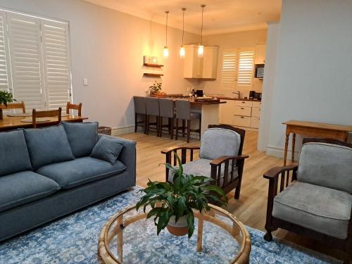 a living room with a couch and chairs and a kitchen at Keerweder in Ceres