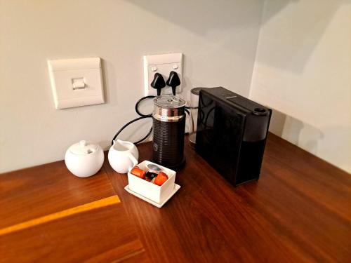 a coffee maker sitting on a wooden floor next to a microwave at Keerweder in Ceres