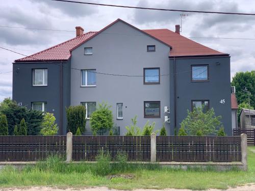 a large white house with a red roof at Drivers in Woźniki