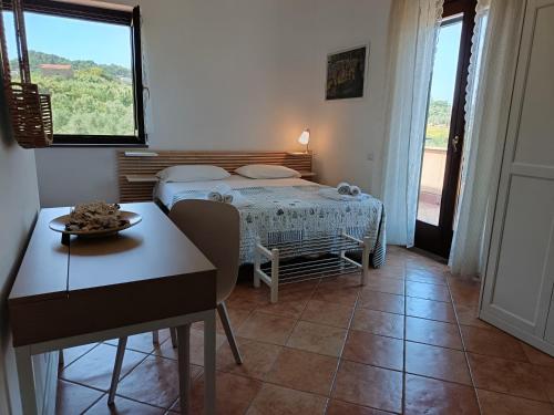 a small room with a bed and a table and a window at Il Maestrale B&B in Castellabate