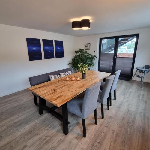 a wooden dining room table with chairs and a potted plant at Pfalztraum Fewo's in Bruchweiler-Bärenbach