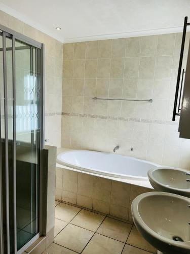 a bathroom with a bath tub and two sinks at Crayfish in Vredenburg