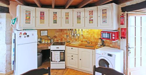 La cuisine est équipée d'un réfrigérateur blanc et d'un lave-vaisselle. dans l'établissement Windmill in France, à Loubès-Bernac