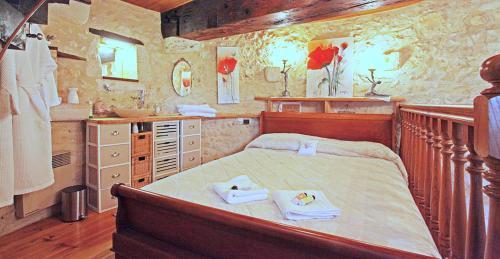 une chambre avec un grand lit avec des serviettes dessus dans l'établissement Windmill in France, à Loubès-Bernac