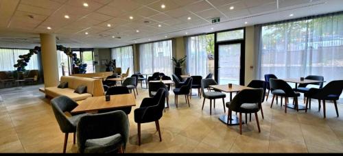 un restaurant avec des tables et des chaises dans un bâtiment dans l'établissement DOMITYS - La Via Domitia, à Gap