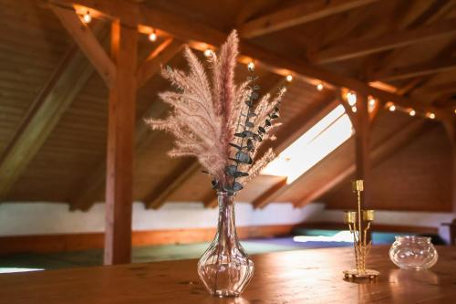 a glass vase with feathers in it on a table at Keresztkúti Erdei Pihenőhely in Kőszeg