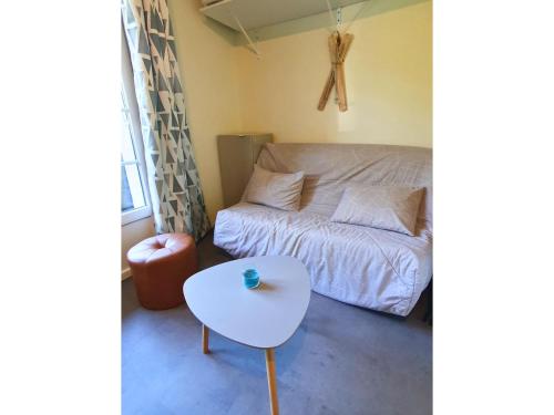 a small bedroom with a bed and a table at La Pause Bourboulienne Appartement RDC avec balcon in La Bourboule