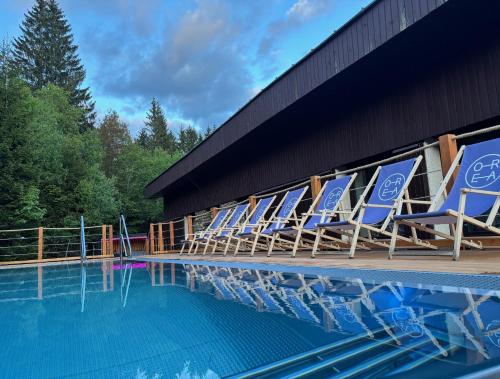 泽勒兹纳·鲁达OREA Resort Horizont Šumava的游泳池旁的一排椅子