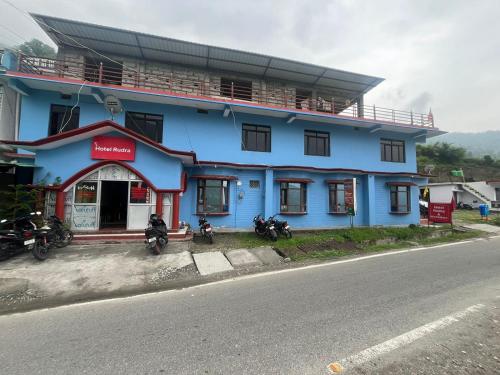 a blue building with motorcycles parked in front of it at Hotel Rudra And Resturant in Gopeshwar