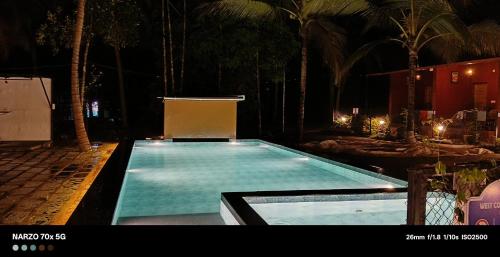 an empty swimming pool in a resort at night at West Coast Gokarna in Gokarna