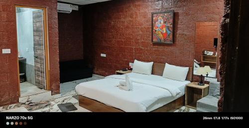 a bedroom with a bed in a brick wall at West Coast Gokarna in Gokarna