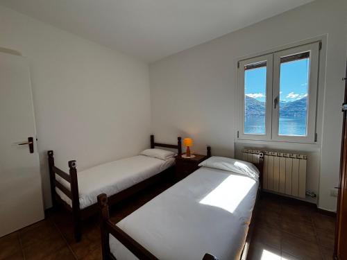 two twin beds in a room with a window at Casa Carol - Larihome A91 in San Siro