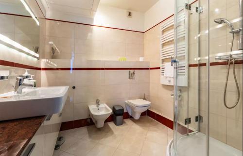 a bathroom with a sink and a toilet and a shower at Sea Towers Luxury Apartment in Gdynia