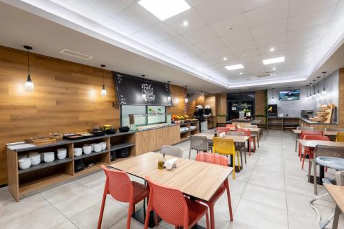 a restaurant with wooden walls and tables and chairs at Avenue Hotel in Burgas City