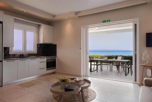 a kitchen and dining room with a view of the ocean at Long Island House, Beachfront Hanioti in Hanioti