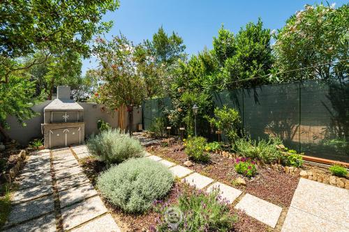 un jardín con una valla y algunas plantas en Grace's House, en Villasimius