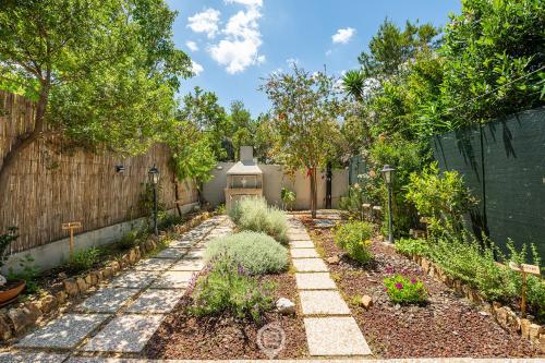 Un jardín trasero con una valla y una pasarela. en Grace's House, en Villasimius